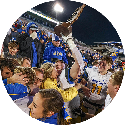 Football player celebrating with a championship trophy in the crowd