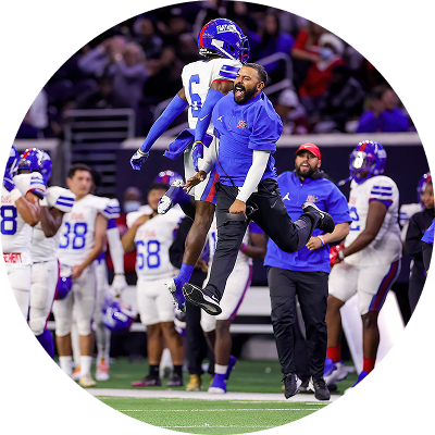 Coach celebrating with a football player on the field